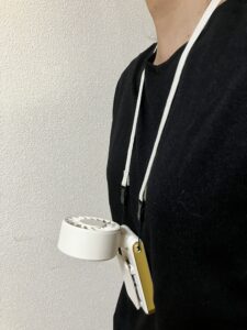 マルチクリップハンディファンを首掛けして服に固定した様子